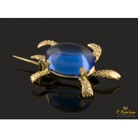 Broche en forma de tortuga realizado en oro amarillo  y presenta una piedra azul